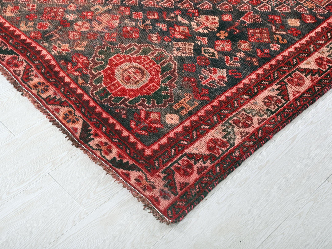a red and black oriental rug on a white floor