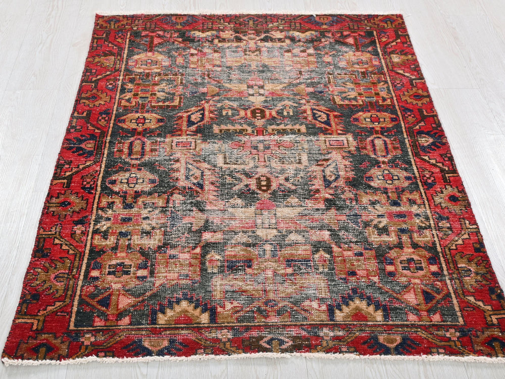 a red and blue oriental rug on a white floor