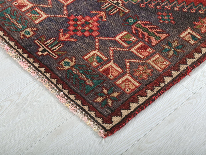 a red and blue oriental rug on a white wooden floor