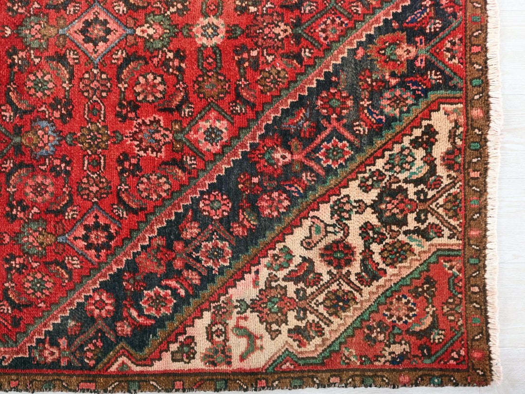 a red rug with a multicolored design on it