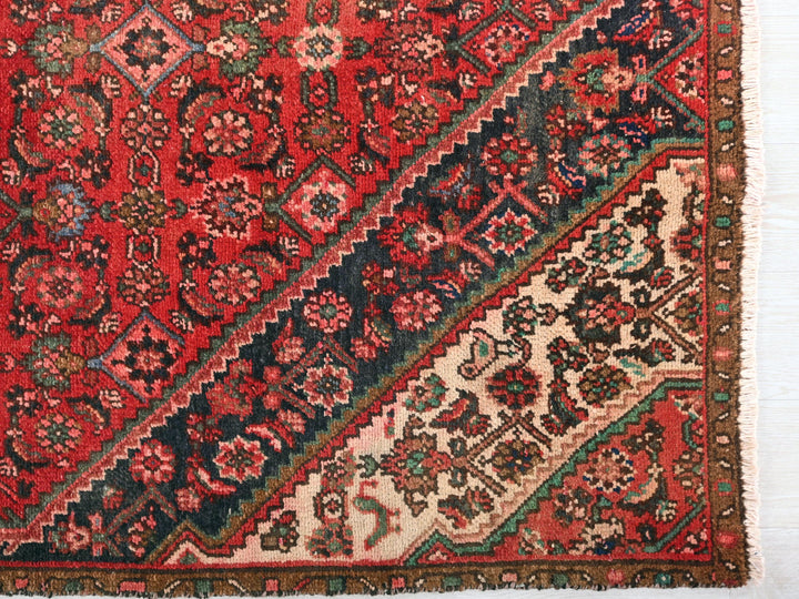 a red rug with a multicolored design on it