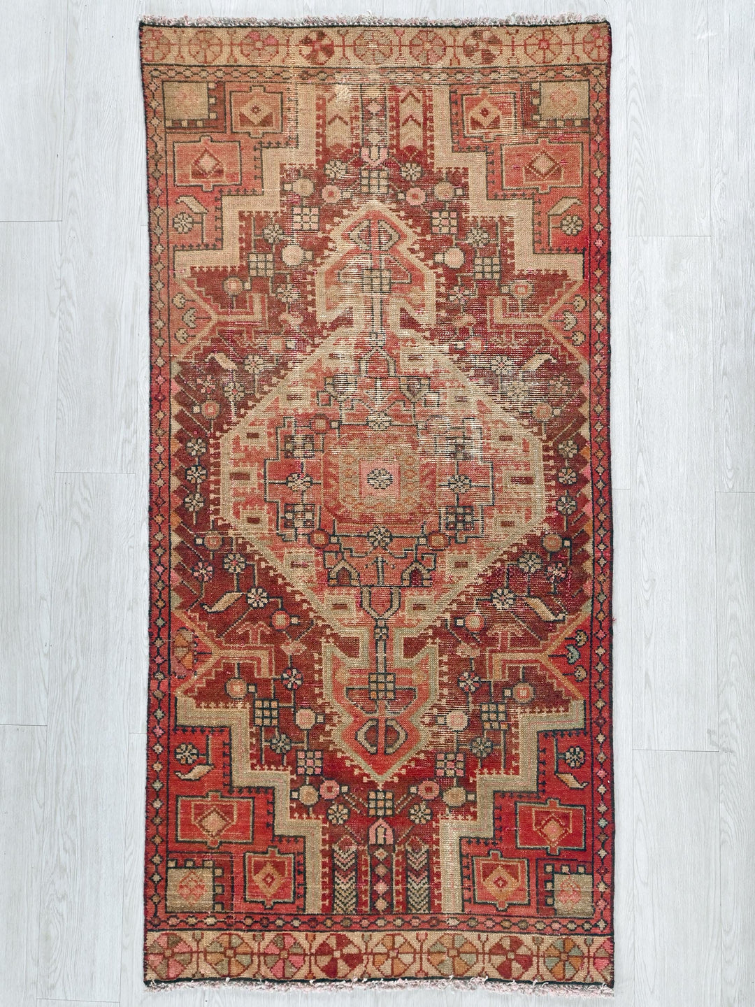 a red and beige rug on a white floor