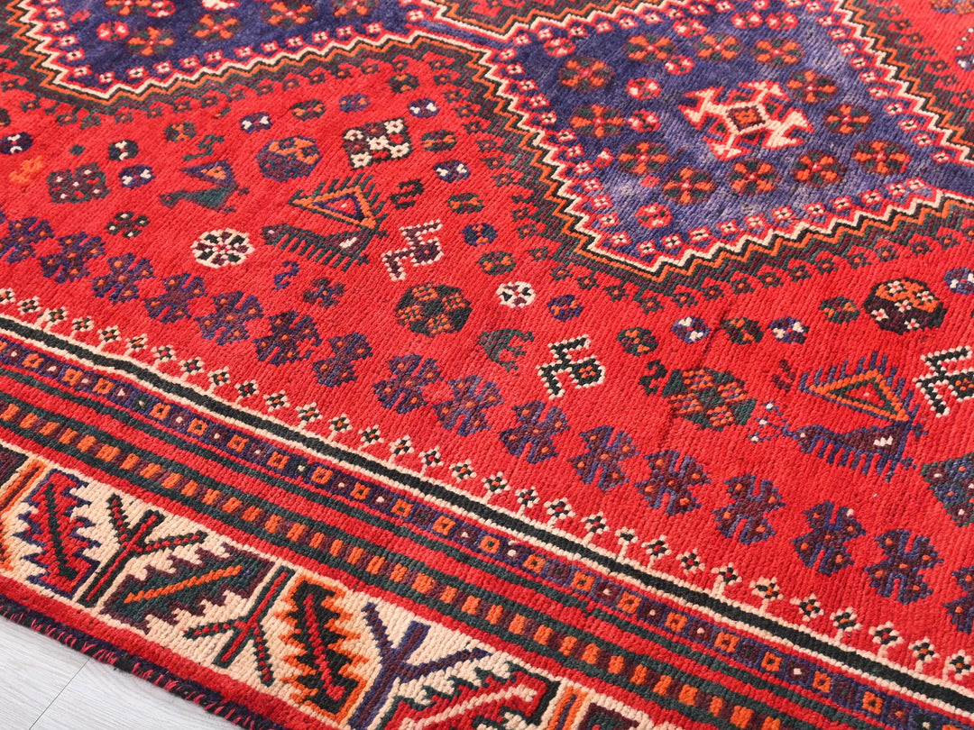 a red oriental rug with a blue border