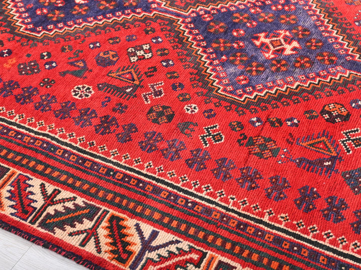 a red oriental rug with a blue border