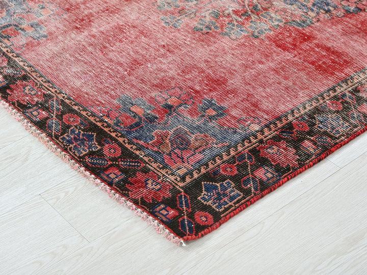 a red rug on a white wooden floor