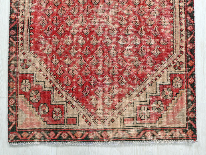 a red rug with a diamond shaped design on it