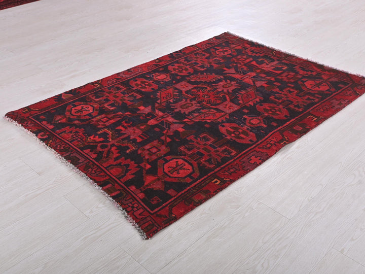 a red and black rug on a white floor
