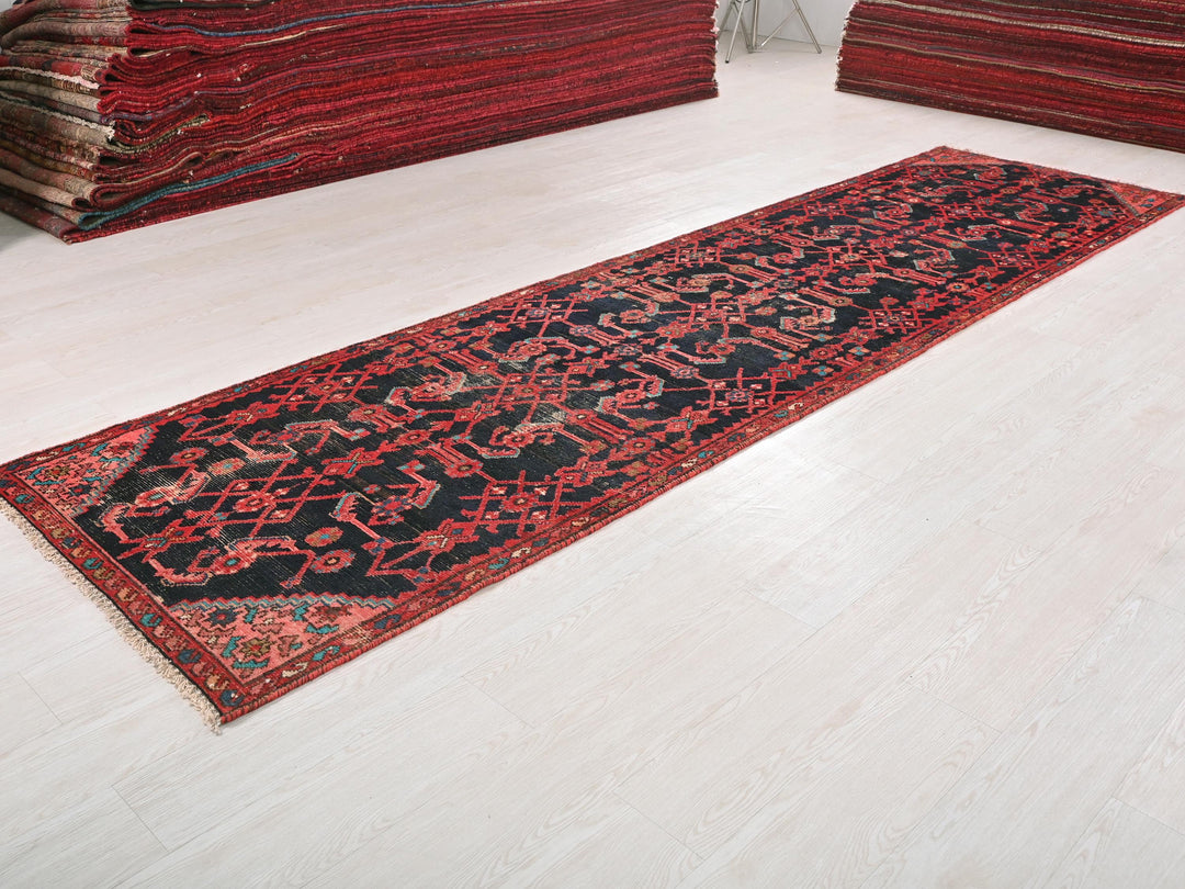 a red and black rug sitting on top of a white floor