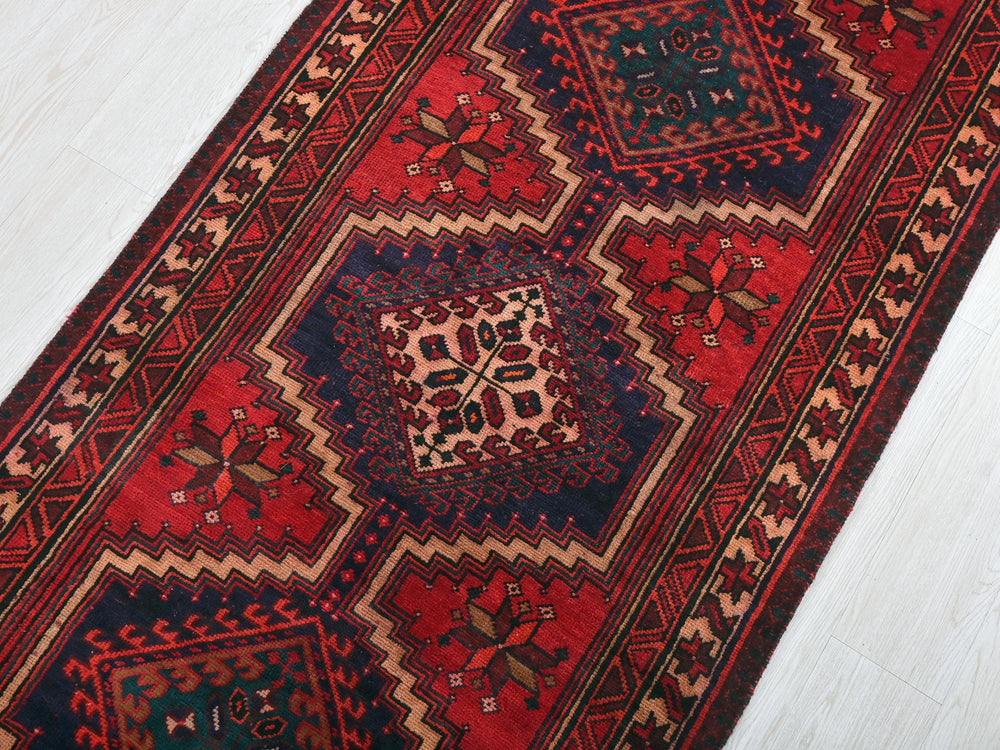 a red and blue rug on a white floor
