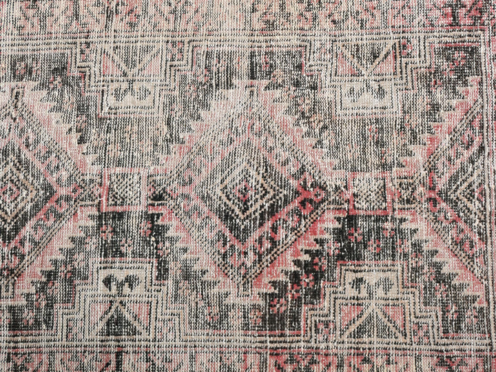 a large oriental rug with a pink and black design