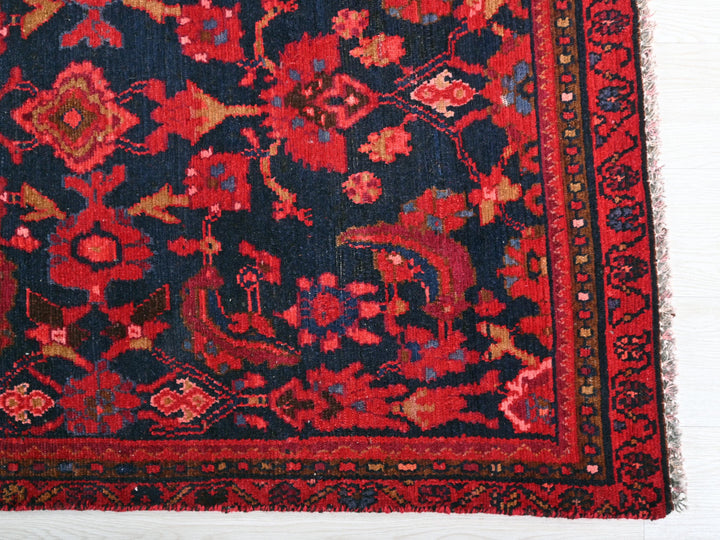 a red and blue rug on a white floor