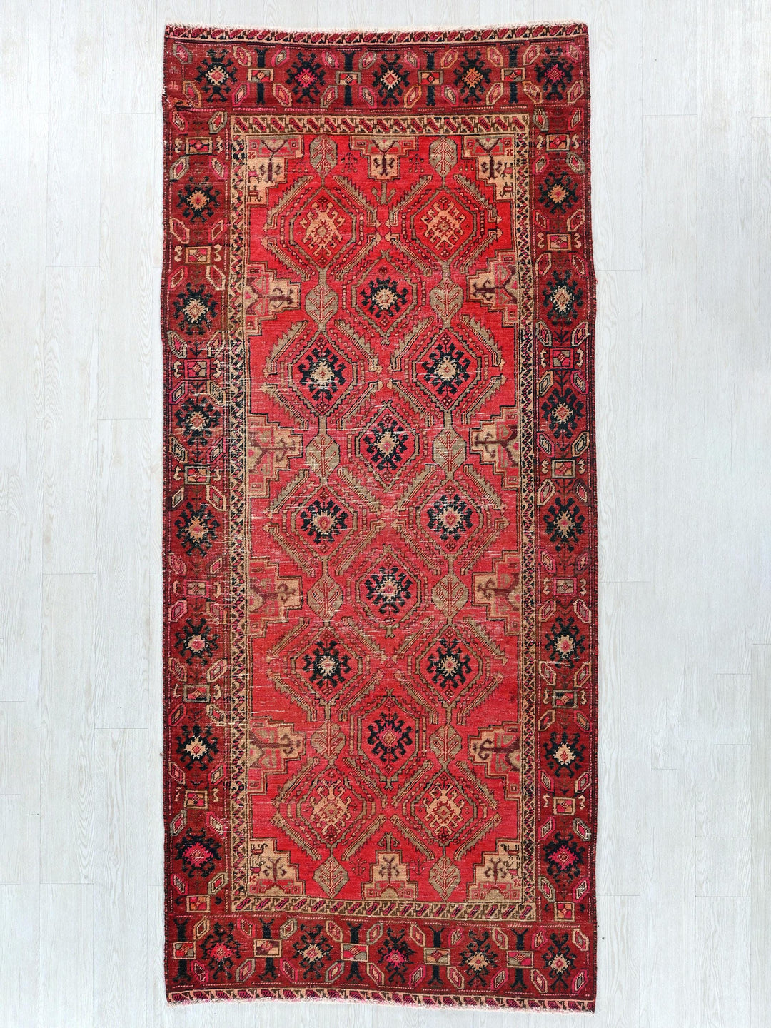 a red rug hanging on a wall