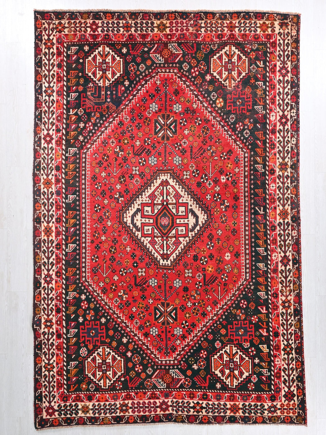 a red and black oriental rug hanging on a wall