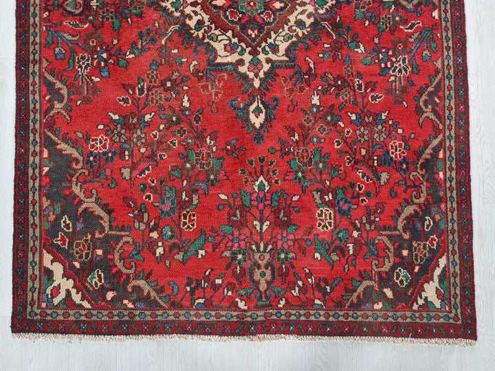 a red rug with a floral design on it