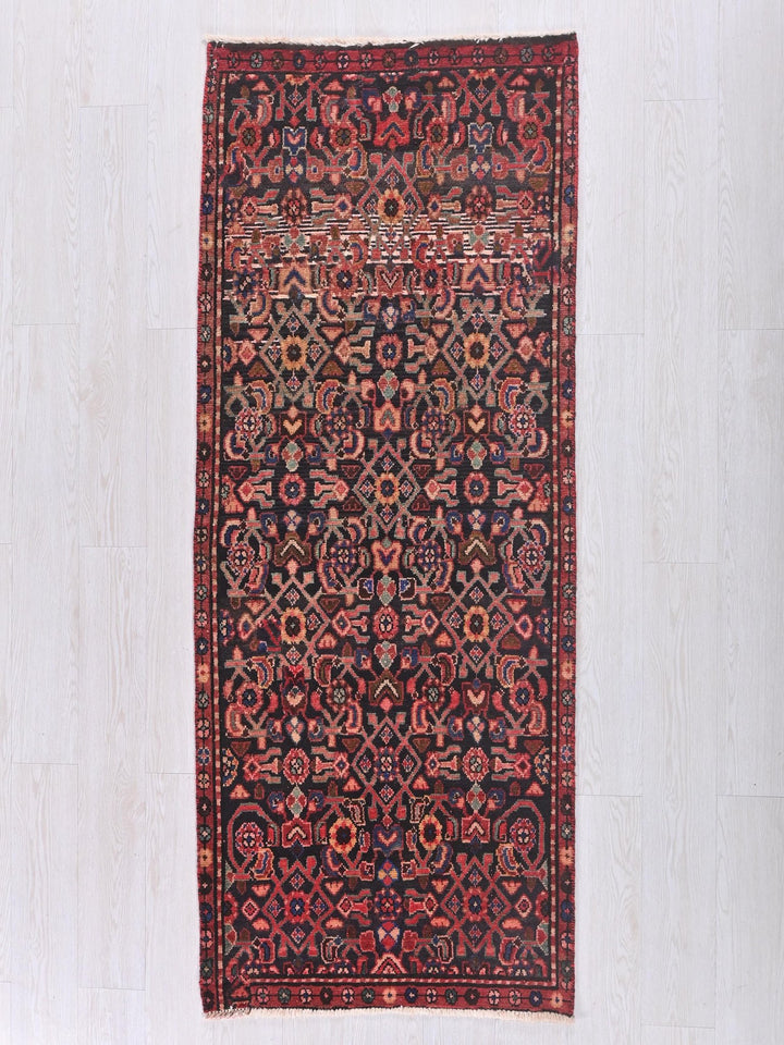 a red and black rug on a white floor