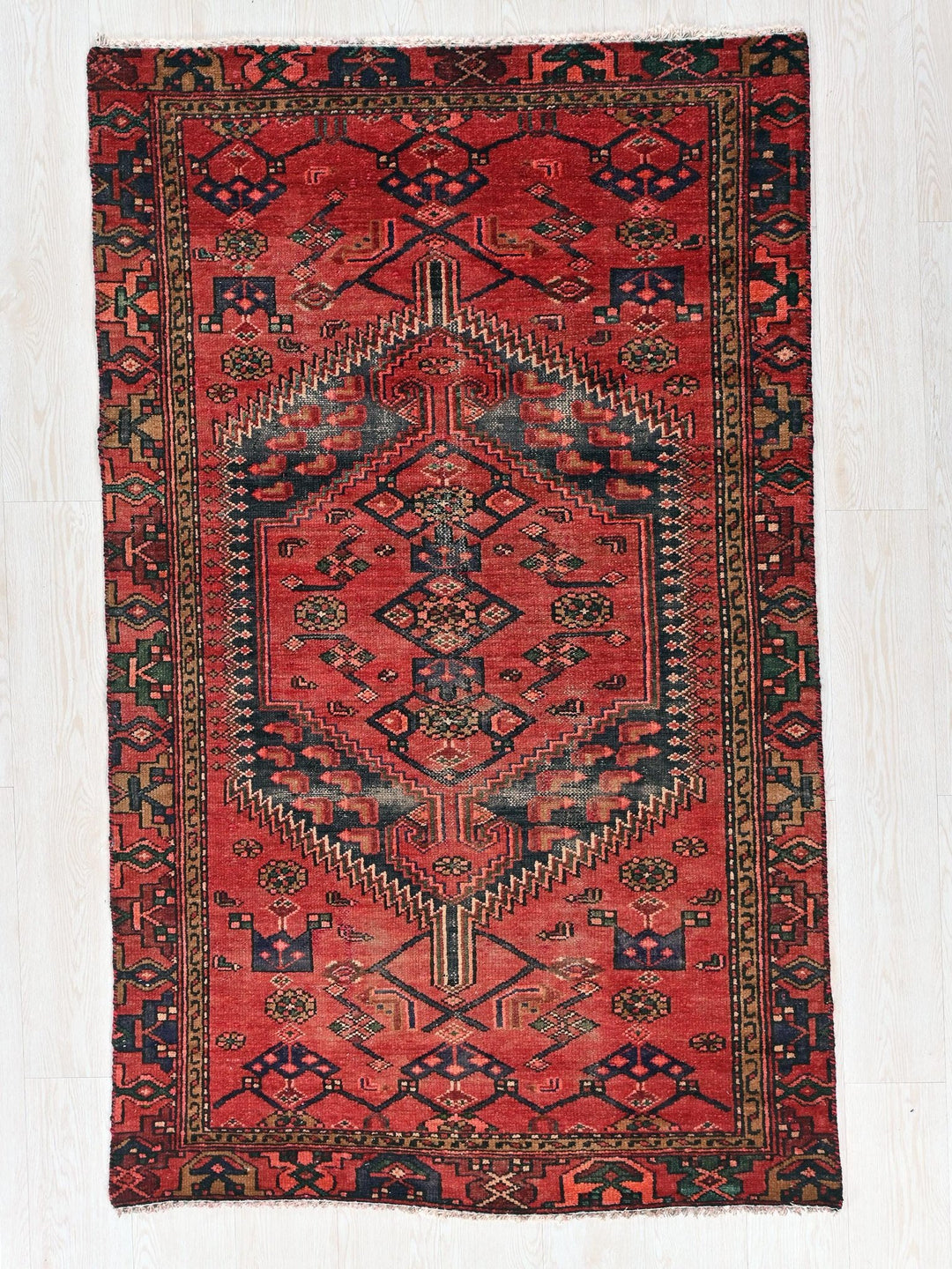 a red and black rug with a design on it