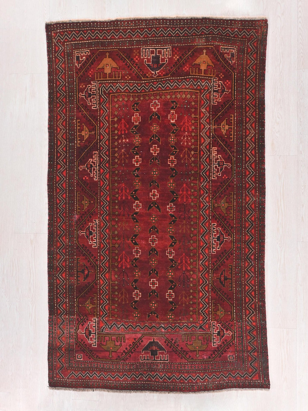 a red rug with a design on the middle of it