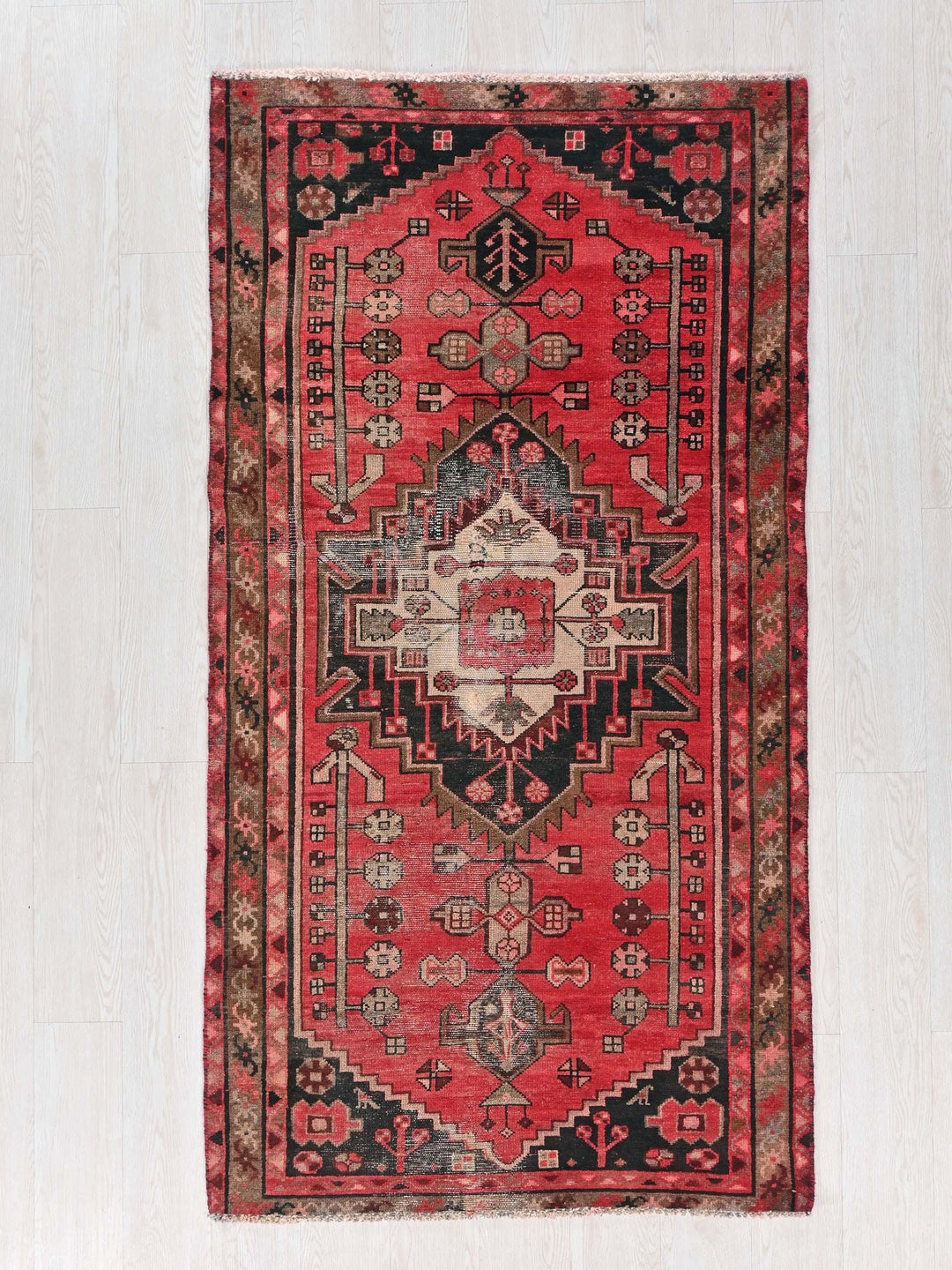 a red and black rug on a white floor