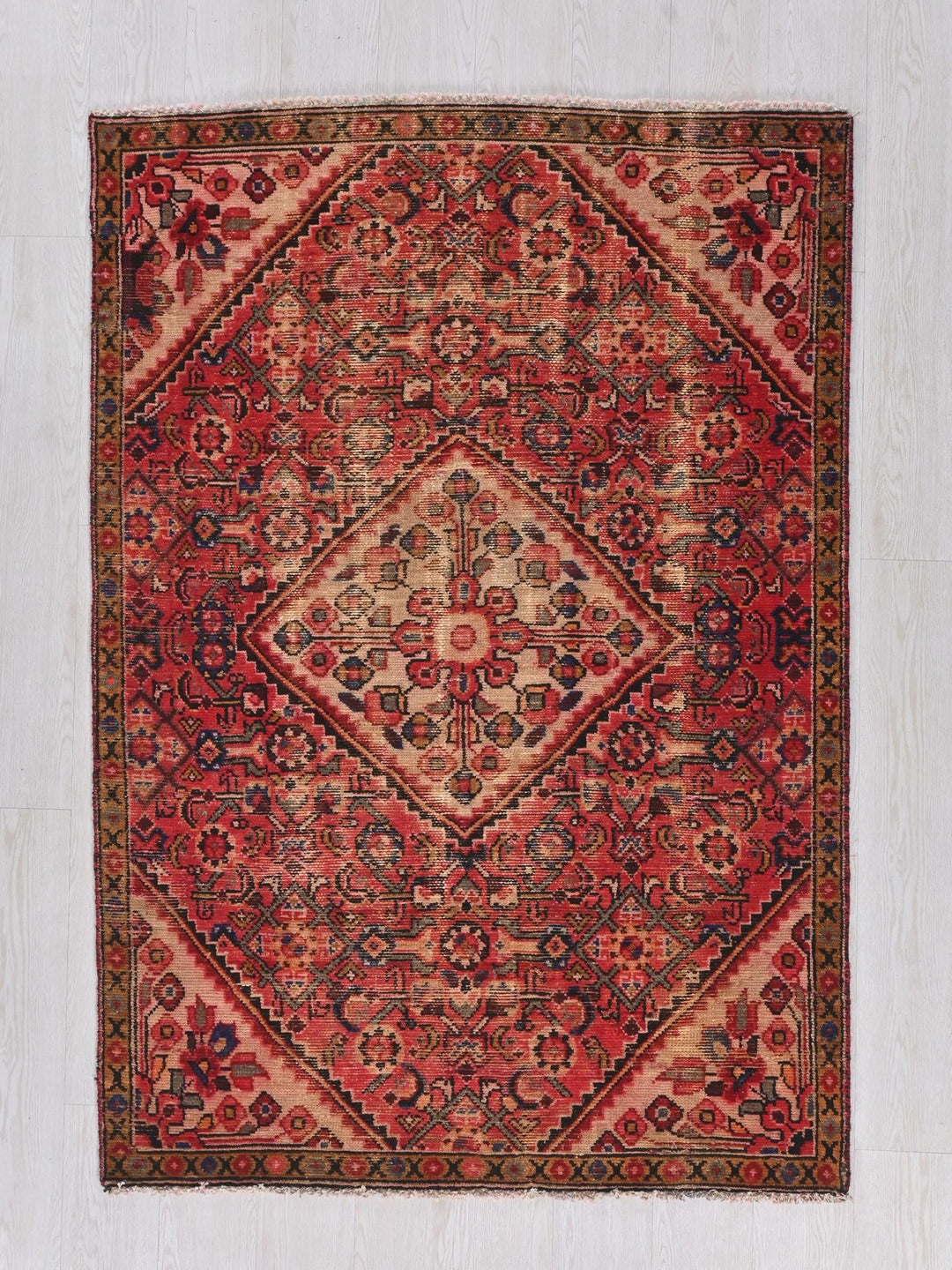 a red rug with a diamond shaped design