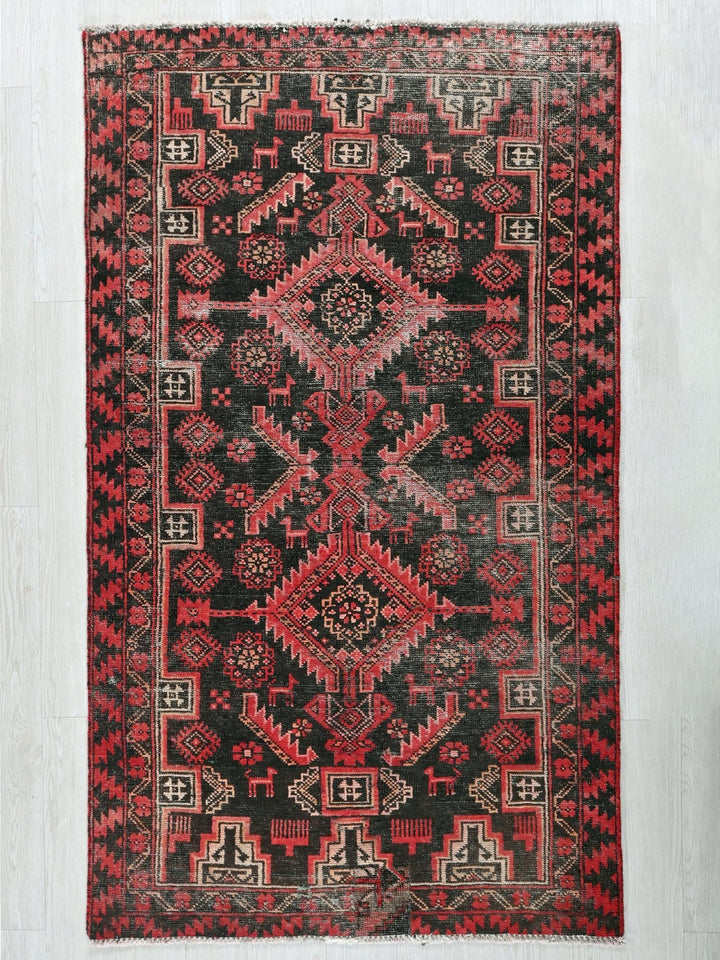 a red and black oriental rug on a white wall