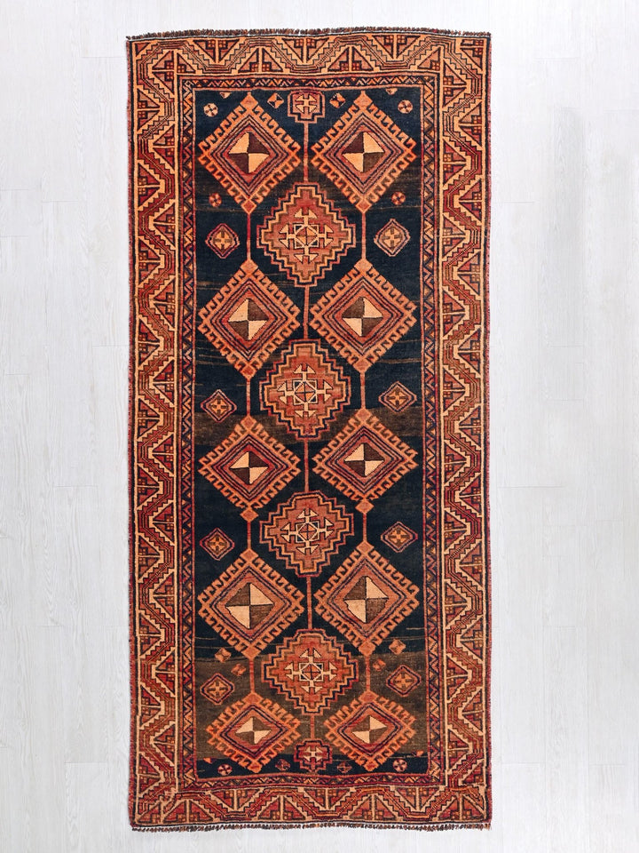 a red and black rug hanging on a wall
