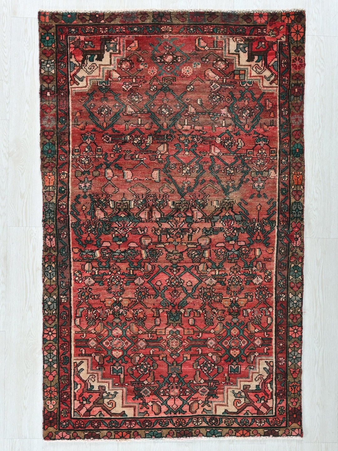 a red rug with a black border on a white background
